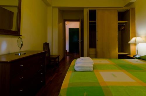 um quarto de hotel com uma cama com toalhas em WelcomeBuddy - Casa dos Avós - Garden & Lake II em Sete Cidades