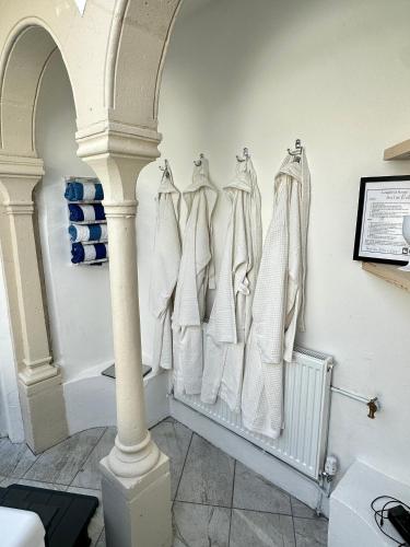 a bathroom with white towels hanging on a wall at Historic Charm: *Perfect For Group Getaways* in Trowbridge