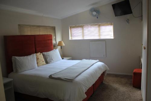 a bedroom with a large bed and a window at Three Arches Guesthouse in Parow