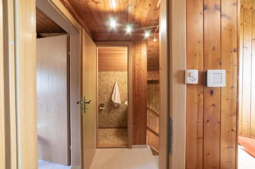un pasillo con paredes de madera y una habitación con puerta en Central, en Wildhaus