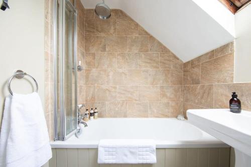 a bathroom with a bath tub and a sink at Cosy Cottage in Beautiful South Downs Walk 2 Pub in Chichester