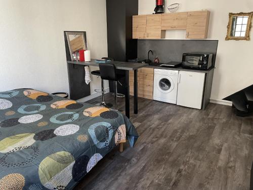 een kleine kamer met een bed en een keuken bij Joli studio en cœur de ville in Limoges