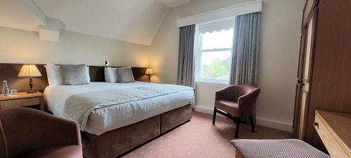 een hotelkamer met een bed en een raam bij Enniskeen Country House Hotel in Newcastle