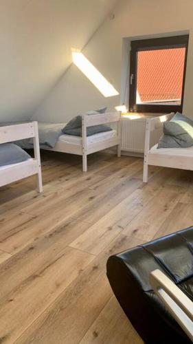 een kamer met 3 stapelbedden en een raam bij Ferienhaus Allgäu Flughafen Memmingen in Benningen