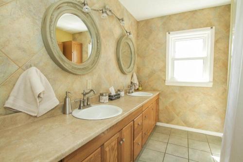 ein Badezimmer mit 2 Waschbecken und einem Spiegel in der Unterkunft Homey Single Family on Old Orchard in Cornwall