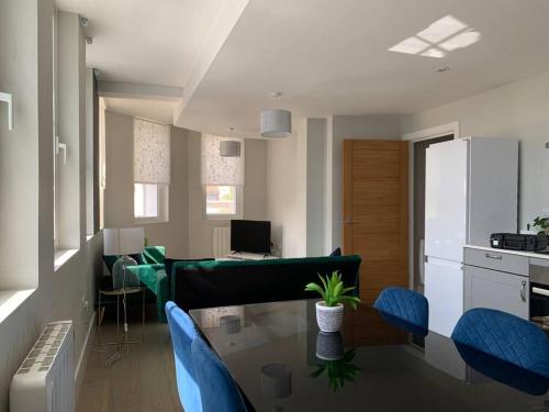 Two bedroom, modern spacious apartment. في برنتوود: غرفة معيشة مع طاولة وكراسي زرقاء