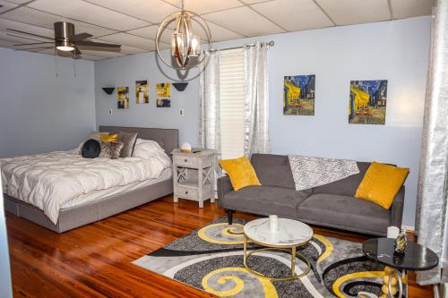a living room with a couch and a bed at Cozy 2BR Apartment, Balcony with City Skyline View, Mardi Gras Park, Free Parking, Wi-Fi in Mobile