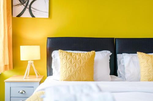 a bedroom with a bed with a yellow wall at Barnes House - Sleeping 8 in Clayton le Moors