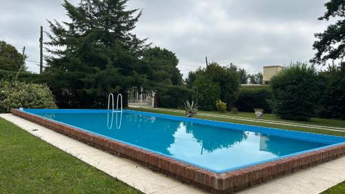 una gran piscina azul en un patio en La Querencia en Mercedes