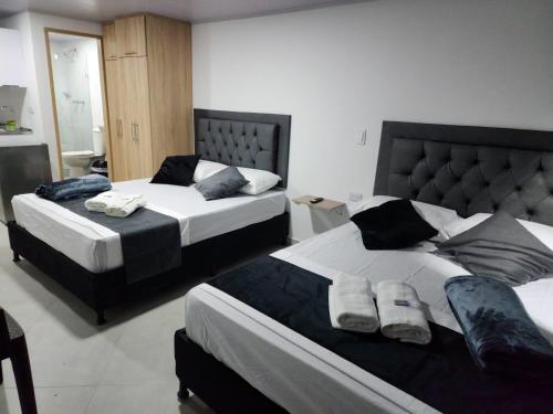 duas camas num quarto de hotel com duas saias em Aparta estudios Estadio la 80 em Medellín