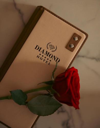 a book with a rose next to a flower at Hotel Diamond Prishtina in Pristina
