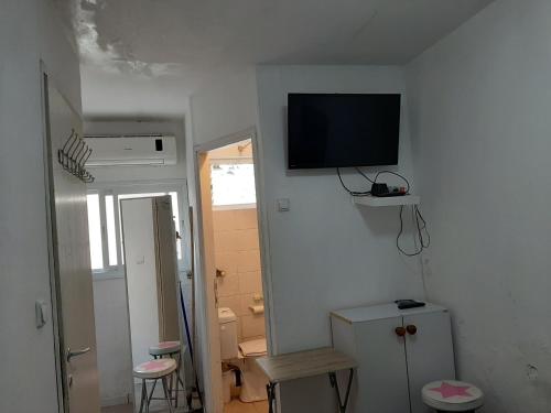 een witte kamer met een televisie aan de muur bij Beach Apartment in Tel Aviv