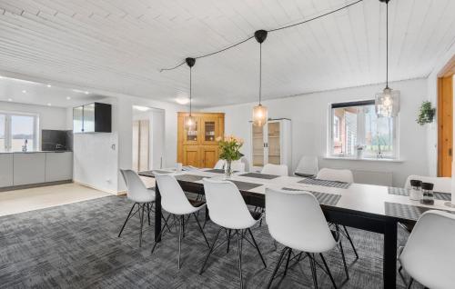 a dining room with a table and white chairs at Five-Bedroom Holiday Home In Kibak in Ørbæk
