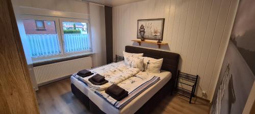 Schlafzimmer mit einem Bett und einem Fenster in der Unterkunft FeWo zwischen den Deichen in Emden