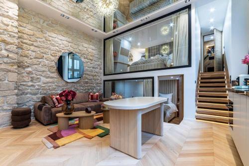 un salon avec une table et un mur en pierre dans l'établissement B Luxe Triplex, Cinema Near Place des Vosges AC, à Paris