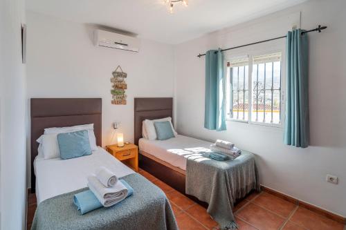 1 dormitorio con 2 camas y ventana en Villa Maroma en Viñuela