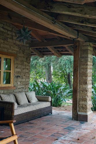 a porch with a couch on a patio at Hotel Rancho San Cayetano in Zitácuaro