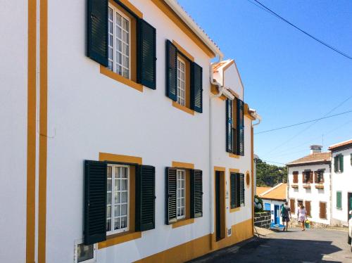 Biały budynek z zielonymi okiennicami w obiekcie WelcomeBuddy - Casa da Praia - Moinhos Beach w mieście Porto Formoso