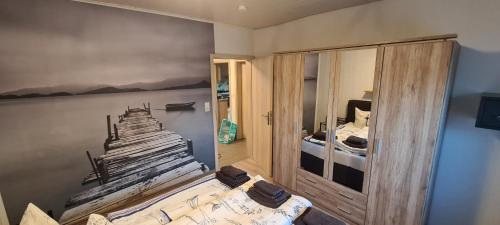 um quarto com uma cama com um quadro na parede em FeWo zwischen den Deichen em Emden