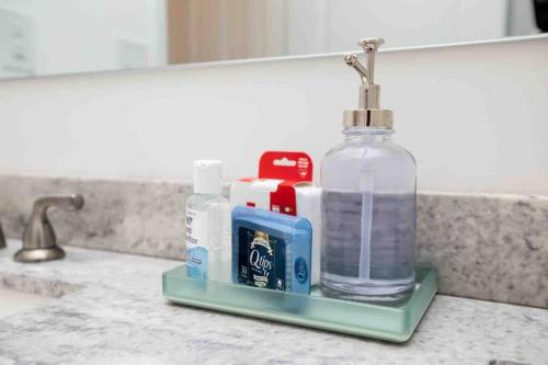 a bathroom sink with a bottle of soap and toothpaste at Farmville Modern Farmhouse in Farmville