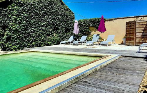 - une piscine avec des chaises et des parasols sur une terrasse dans l'établissement Le Mas De La Vigne, à Violès