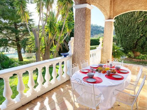 - une table avec des assiettes de nourriture sur une terrasse couverte dans l'établissement Villa au calme à Sanary, climatisée, avec piscine, à Sanary-sur-Mer