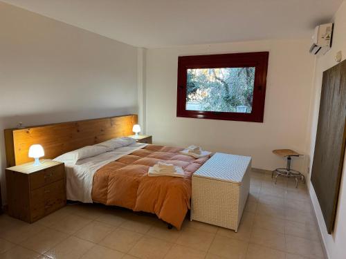 a bedroom with a large bed and a window at Villa Rama in Aci Castello