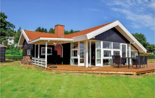 a home with a large deck and a house at Three-Bedroom Holiday Home In Bjert in Binderup Strand