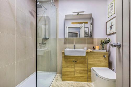 uma casa de banho com um chuveiro, um lavatório e um WC. em Spacious & Stylish Home Nr Chichester em Fishbourne