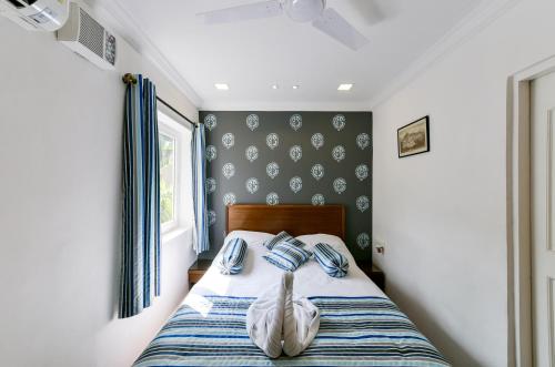a bedroom with a bed with blue and white sheets at 2 Bedroom Apartment in Resort on Candolim Beach in Baga