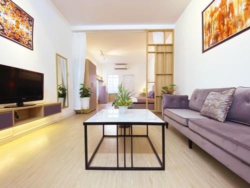 a living room with a purple couch and a table at La Vie - Saigon Homestay in Ho Chi Minh City