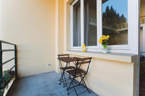 two chairs sitting on a porch with a window at Ostello Bello Lake Como in Como