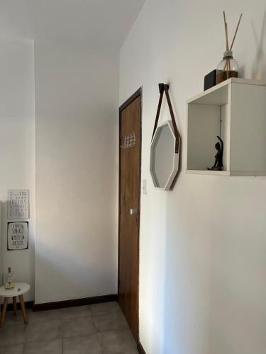 a hallway with a wooden door and a mirror at ReMar na Barra, ENSEADA DO PORTO in Salvador