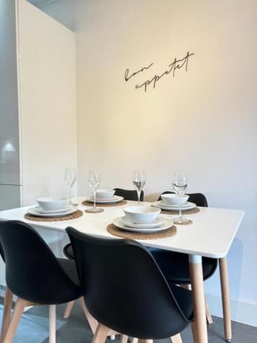 a dining room table with black chairs and a white dining room table at Luxury Canal-side Apartment, Hemel Hempstead, Free parking, Perfect for Contractors in Hemel Hempstead
