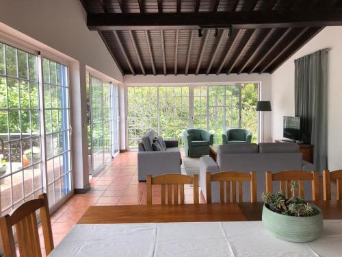 a living room with a table and chairs at Casa do Monte – Sea sight in Lagoa