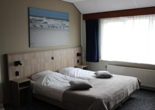 a bedroom with a bed with two pillows on it at Hotel "De Klok" in Buren