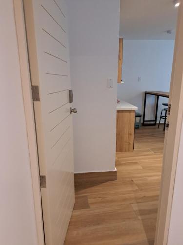 a hallway with a white door and a kitchen at Venue Studios in Lima