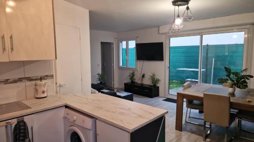 a kitchen and living room with a table and a dining room at Joli appart à 10mn de paris in Bezons