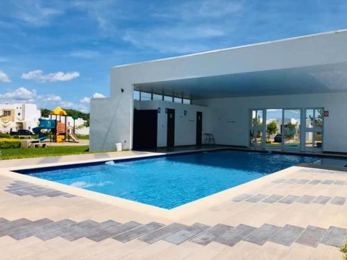una gran piscina frente a una casa en Moderna casa amueblada en residencial privada, en San Miguel