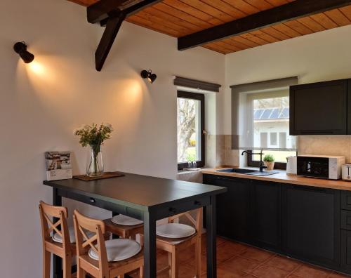 una cocina con mesa negra y sillas en Cooles Lofthouse mit Pool, en Kiskunmajsa