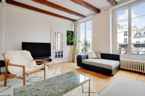 sala de estar con sofá y TV en Center of Paris apartment for 4 people !, en París