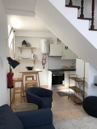 a living room with a blue couch and a kitchen at Uma Casa na Caloura - Blue & Beach in Lagoa