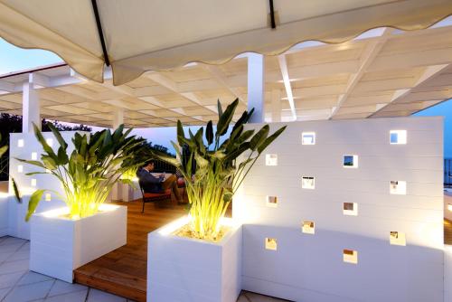 a patio with two potted plants and lights at Hotel Villa Durrueli Resort & Spa in Ischia