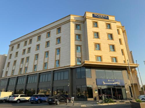 a large building with cars parked in front of it at Romera Hotel in Jeddah