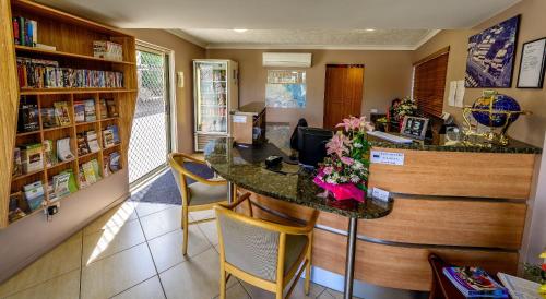 a restaurant with a counter and chairs in a room at Rocky Gardens Motor Inn Rockhampton in Rockhampton