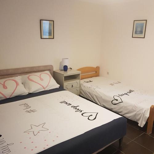 2 Betten in einem Zimmer mit Schreibmaschine in der Unterkunft Apartments Nenadić in Utjeha