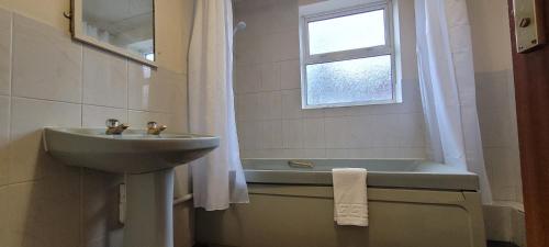 a bathroom with a sink and a bath tub at Reading Budget Apartments in Reading