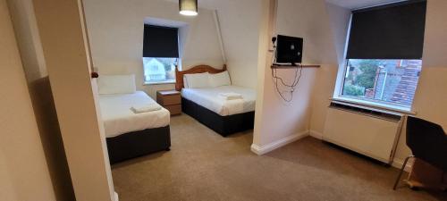 a small room with two beds and a television at Reading Budget Apartments in Reading