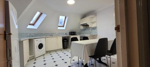 a kitchen with a table and a washing machine at Reading Budget Apartments in Reading