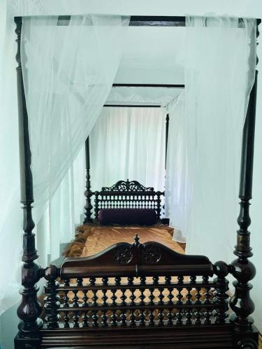 Pearl In Munroe Island في Munroe Island: سرير مع مظلة في غرفة النوم